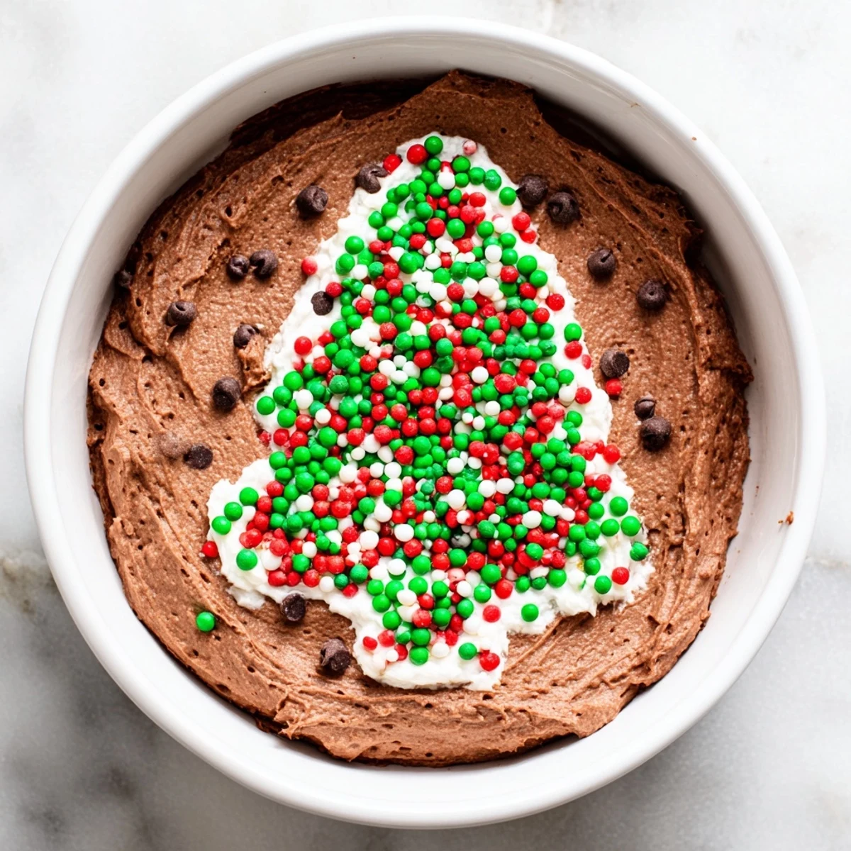 Festive Tree Brownie Dip, swirled with sprinkles, served with pretzel sticks and fresh strawberries.