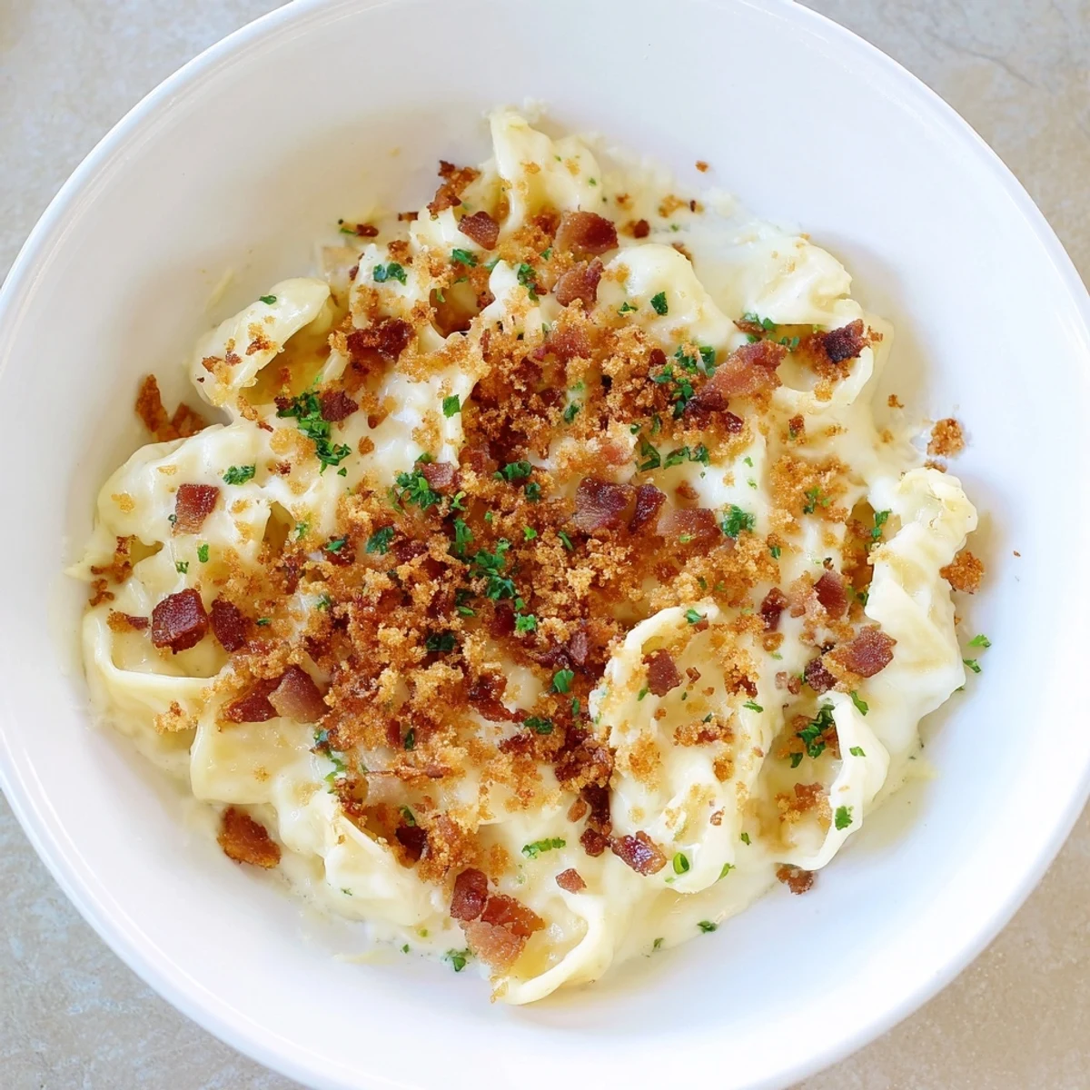 A close-up of Tinis Mac and Cheese with Bacon, showing a bubbly, golden-brown topping.