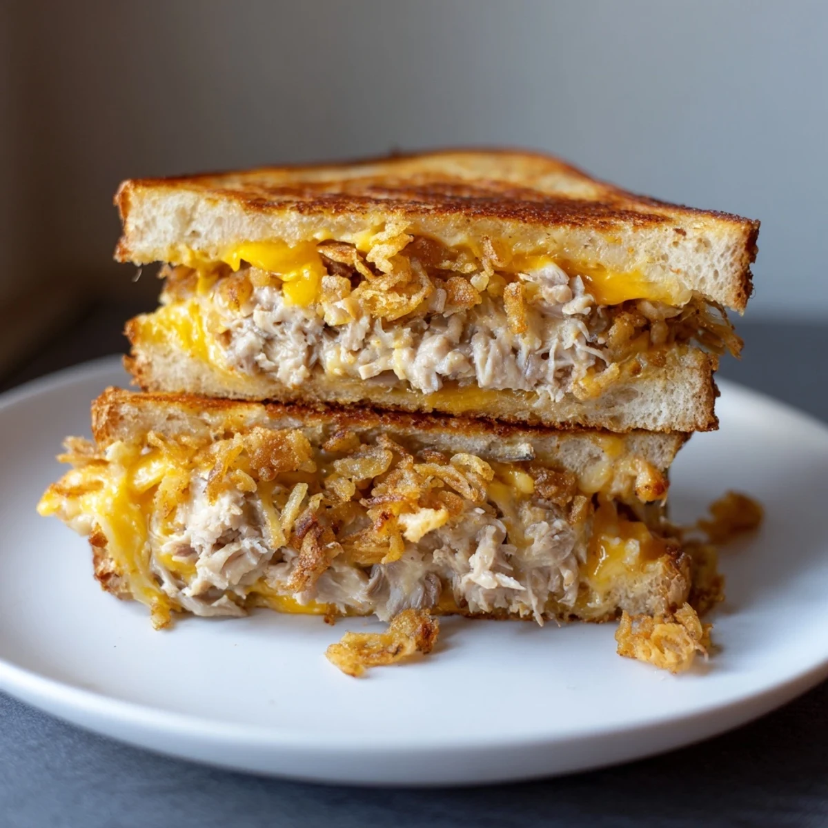 Warm, crispy-edged Crispy Shallot Chicken Grilled Cheese ready to be sliced, perfect for lunch.