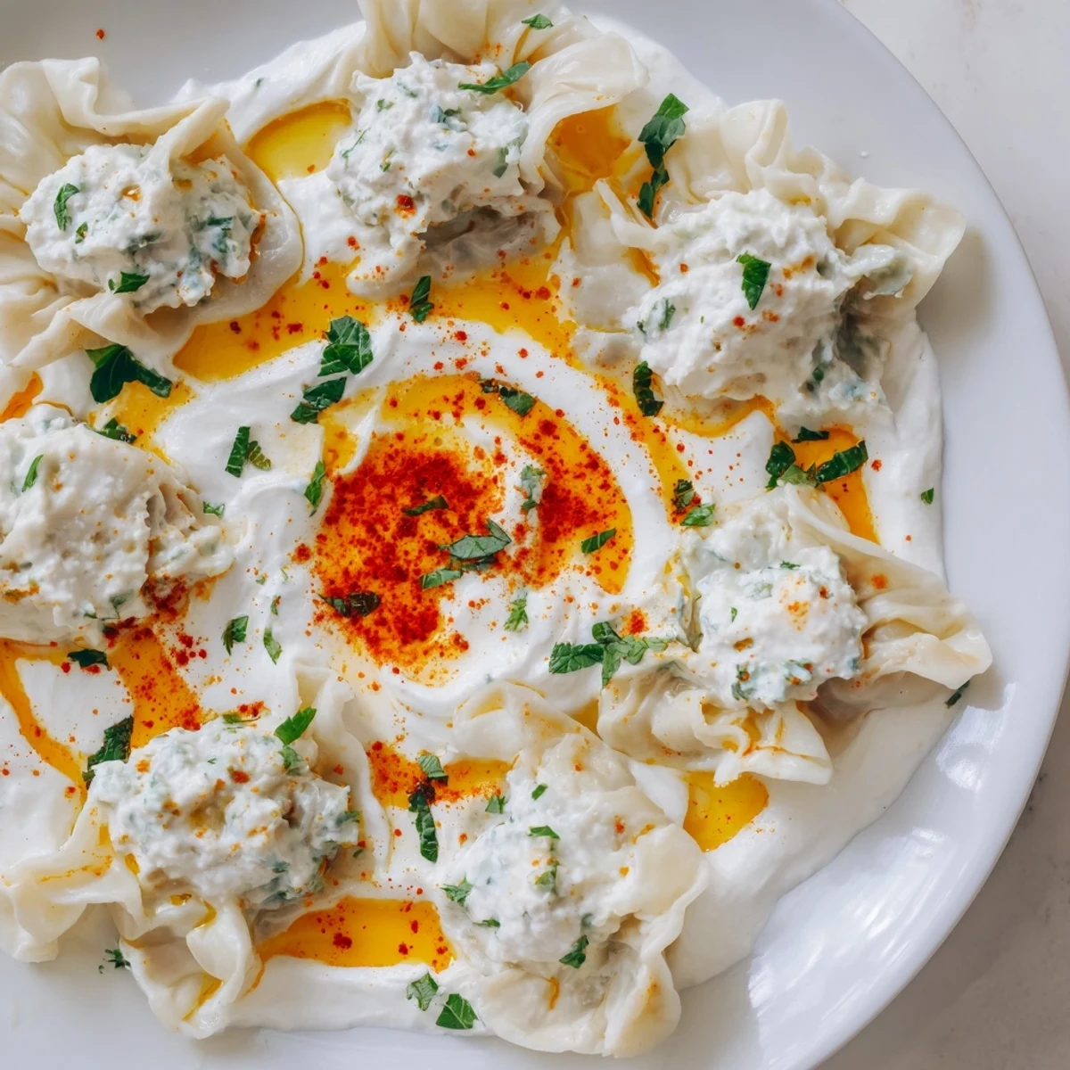 Delicious and flavorful Turkish cheesy manti, with melting cheese filling, swimming in creamy yogurt.