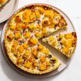 Fragrant steam rises from this Potato Crust Quiche, showcasing the baked squash and creamy cheeses.