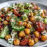 Cold Chickpea Salad with Lemon Herbs in a white bowl, garnished with fresh parsley and mint sprigs.