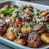 Crispy sheet pan gnocchi tossed with savory sausage, colorful peppers, and onions, topped with Parmesan for a hearty, easy dinner.  