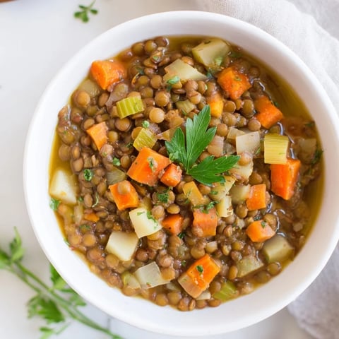 Steaming bowl of Classic Lentil and Herb Soup, garnished with parsley, ready to be enjoyed.