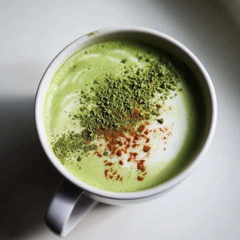Steaming mug of Maple Cinnamon Gingerbread Matcha Oat Latte, perfect for a chilly morning.