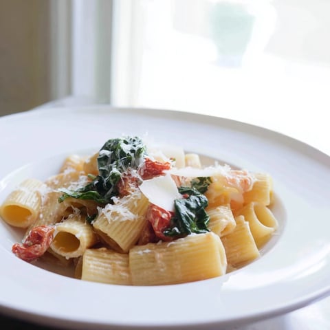 Creamy Sun-Dried Tomato Spinach Cottage Cheese Pasta, ready to serve and garnished with fresh basil.