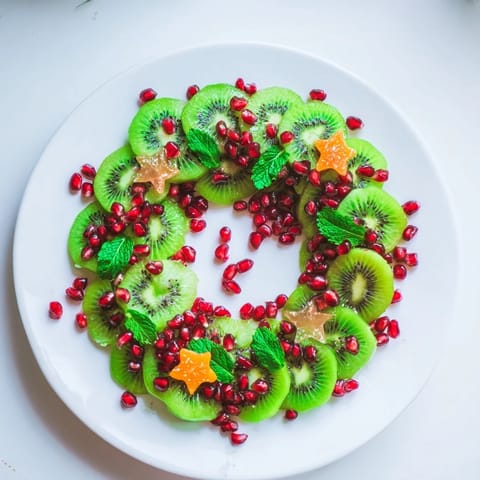 A festive holiday fruit platter of Kiwi and Pomegranate Christmas Wreath, perfect for a fresh dessert.