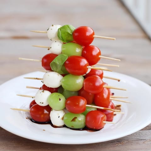 Vibrant red and green Caprese skewer tree, ready to serve, a vegetarian Italian appetizer favorite.