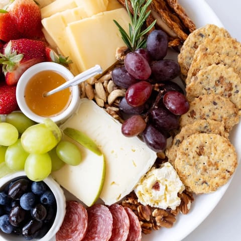 A beautifully arranged quick charcuterie snack board displays various cheeses and cured meats for an easy appetizer.