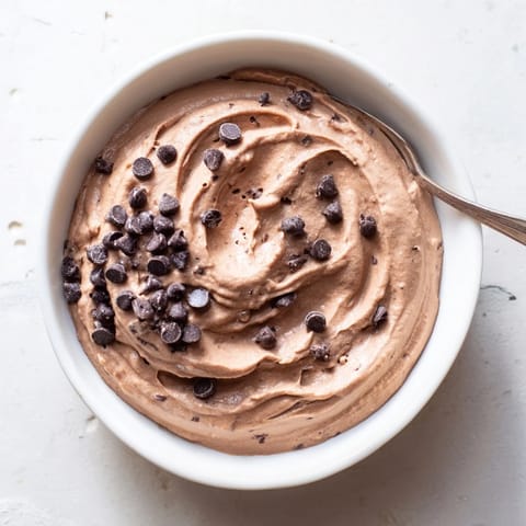 Smooth, rich chocolate hummus ready to dip with fresh strawberries, a delicious sweet treat.