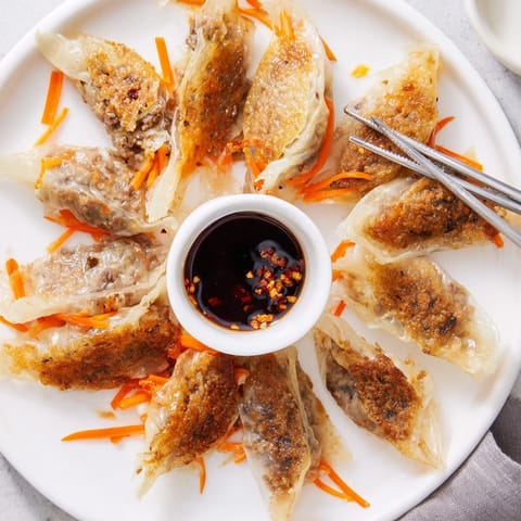 A close-up of Crispy Rice Paper Dumplings served with a small bowl of tangy, spicy dipping sauce.  