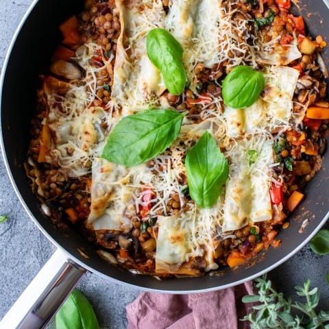 Golden-brown One-Pan Smoky Veggie Lentil Lasagne bubbling with smoky lentils, mushrooms, and zucchini, topped with melted mozzarella and fresh basil.