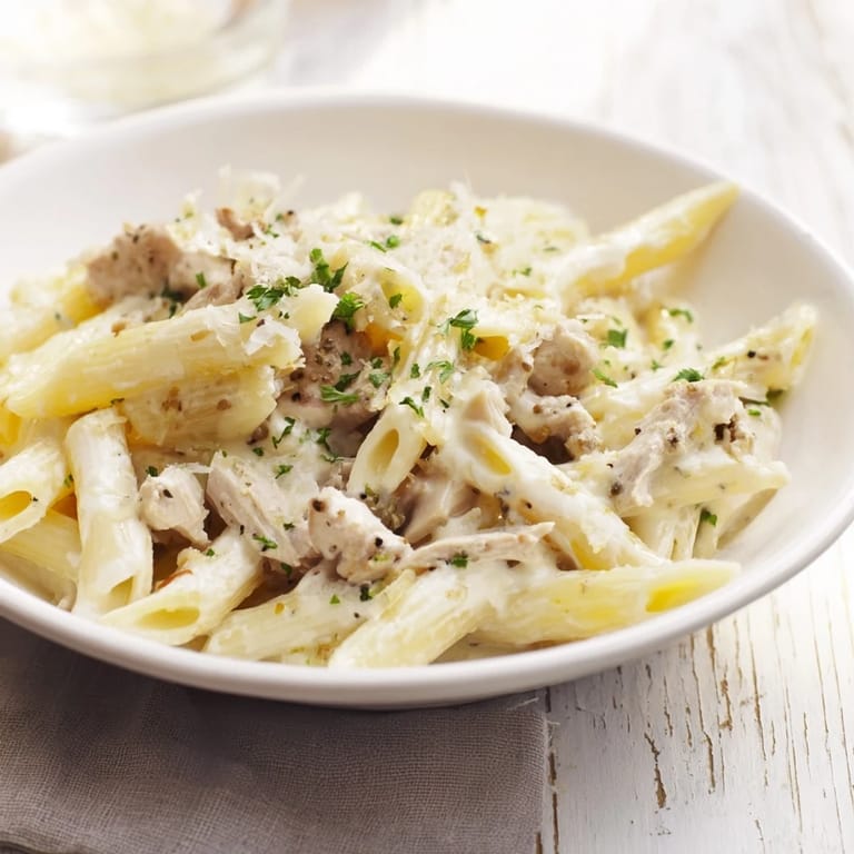 Golden Tinis Creamy Chicken Pasta: a close-up of the flavorful pasta topped with fresh parsley.