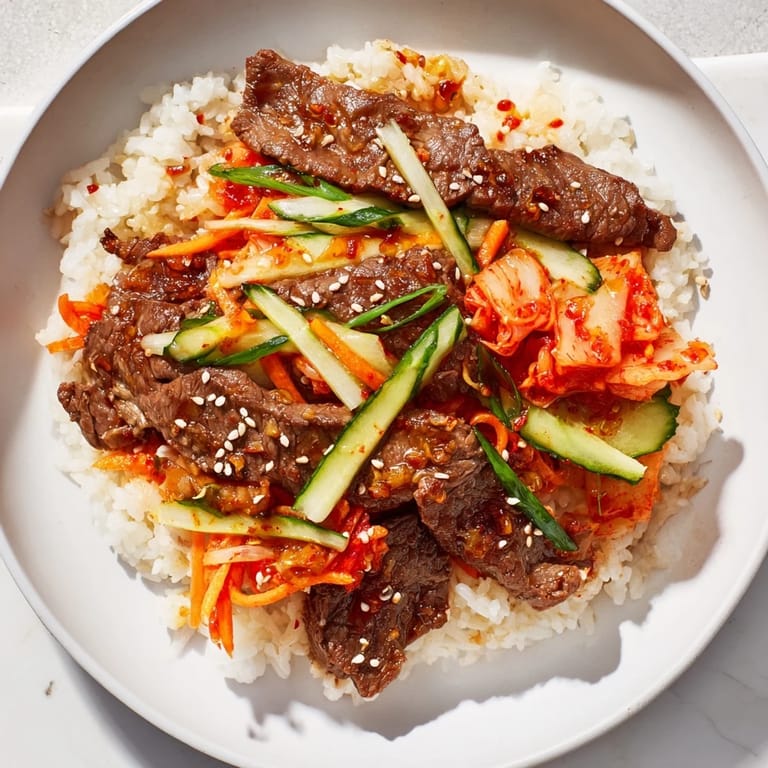 A steaming bowl of bulgogi with rich marinated beef, colorful veggies, and sesame seeds; a satisfying Korean dinner.