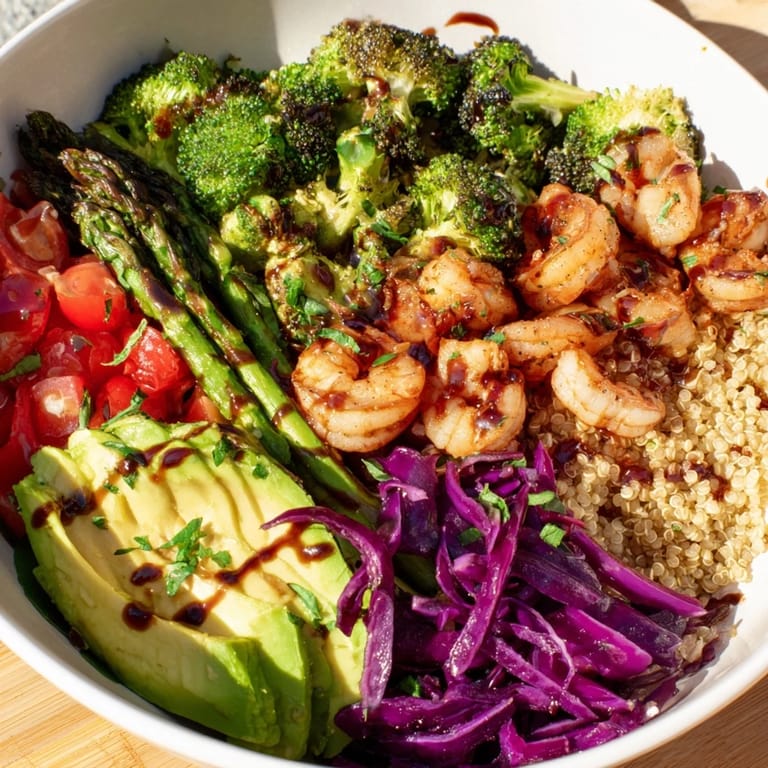 Close-up of a Detox Buddha Bowl with Shrimp and Quinoa, showcasing red cabbage, tomato, and asparagus for a fresh, nutrient-packed meal.