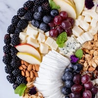 A vibrant Yin-Yang Balance appetizer board showcasing contrasting cheeses, fruits, and crackers.