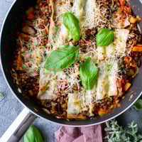 Golden-brown One-Pan Smoky Veggie Lentil Lasagne bubbling with smoky lentils, mushrooms, and zucchini, topped with melted mozzarella and fresh basil.