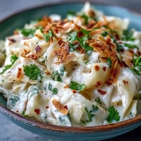 Tender slices of Coconut Braised Cabbage simmer in a golden coconut milk sauce flecked with aromatic spices.