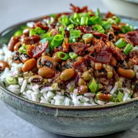 Hoppin John with black-eyed peas, crispy bacon, and fluffy rice in a white bowl.