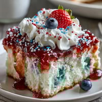 Festive Memorial Day Red White Blue Poke Cake with creamy clouds of topping.